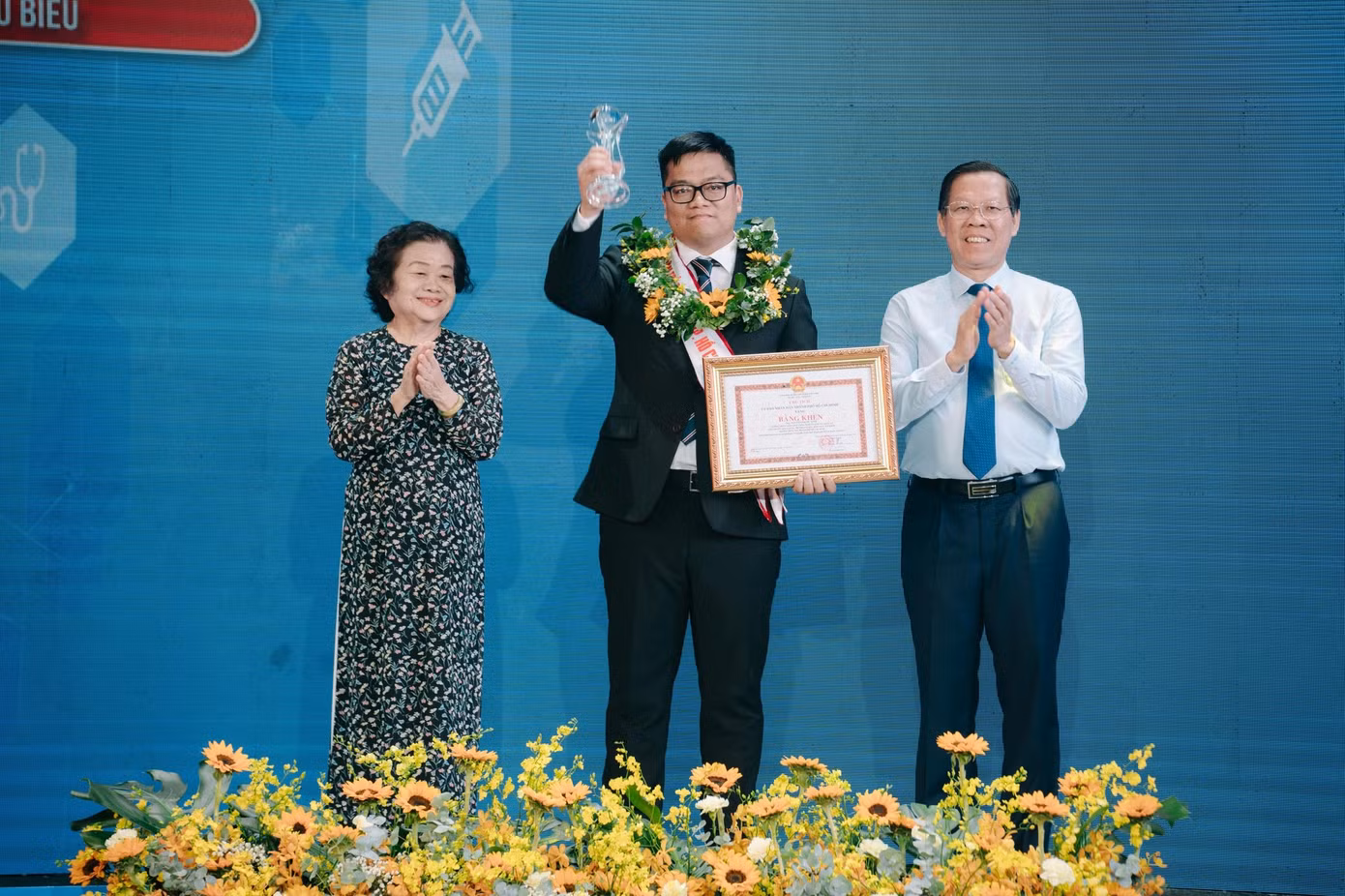 Ông Phan Văn Mãi - Chủ tịch UBND TPHCM và nguyên Phó Chủ tịch nước - bà Trương Mỹ Hoa trao bằng khen cho anh Nguyễn Phước Vinh - Trưởng phòng Khoa học công nghệ và Hợp tác quốc tế, Phó Trưởng khoa Dược, Trường Đại học Khoa học sức khỏe, Đại học Quốc gia TPHCM.