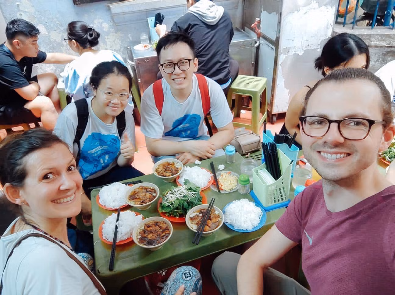 Hai du khách châu Âu cùng các bạn sinh viên thưởng thức món bún chả, trải nghiệm ẩm thực Hà thành.