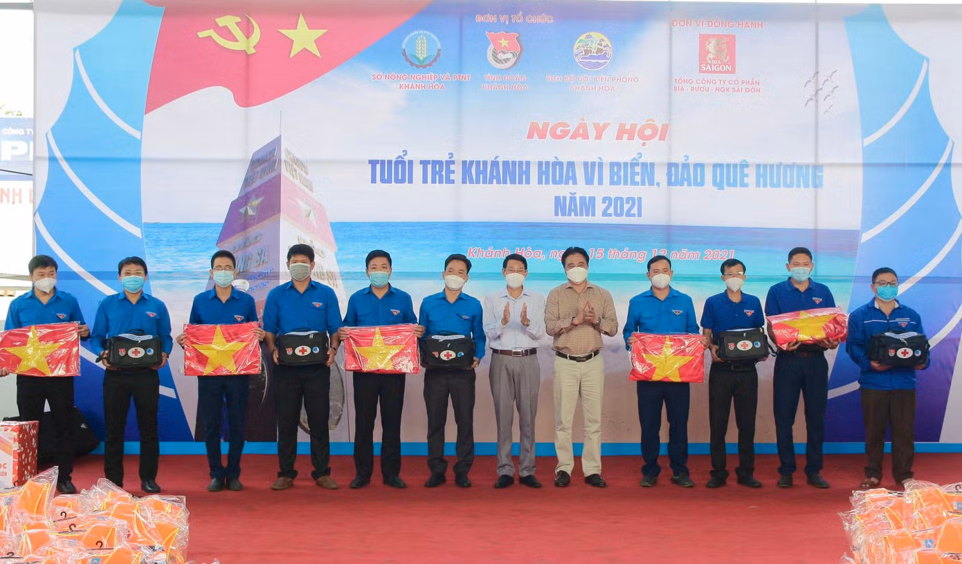 Ông Nguyễn Khắc Toàn và ông Đinh Văn Thiệu trao thiết bị giám sát hành trình (ảnh trên), cờ Tổ quốc và túi y tế cho ngư dân trẻ bám biển.