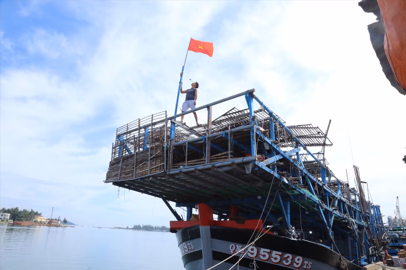 Ngư dân thay mới cờ Tổ quốc sẵn sàng vươn khơi. Ảnh: Hoài Văn
