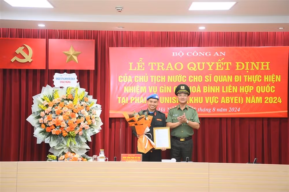Thừa ủy quyền, Thứ trưởng Phạm Thế Tùng trao Quyết định của Chủ tịch nước cho Trung tá Trịnh Xuân Hiển.