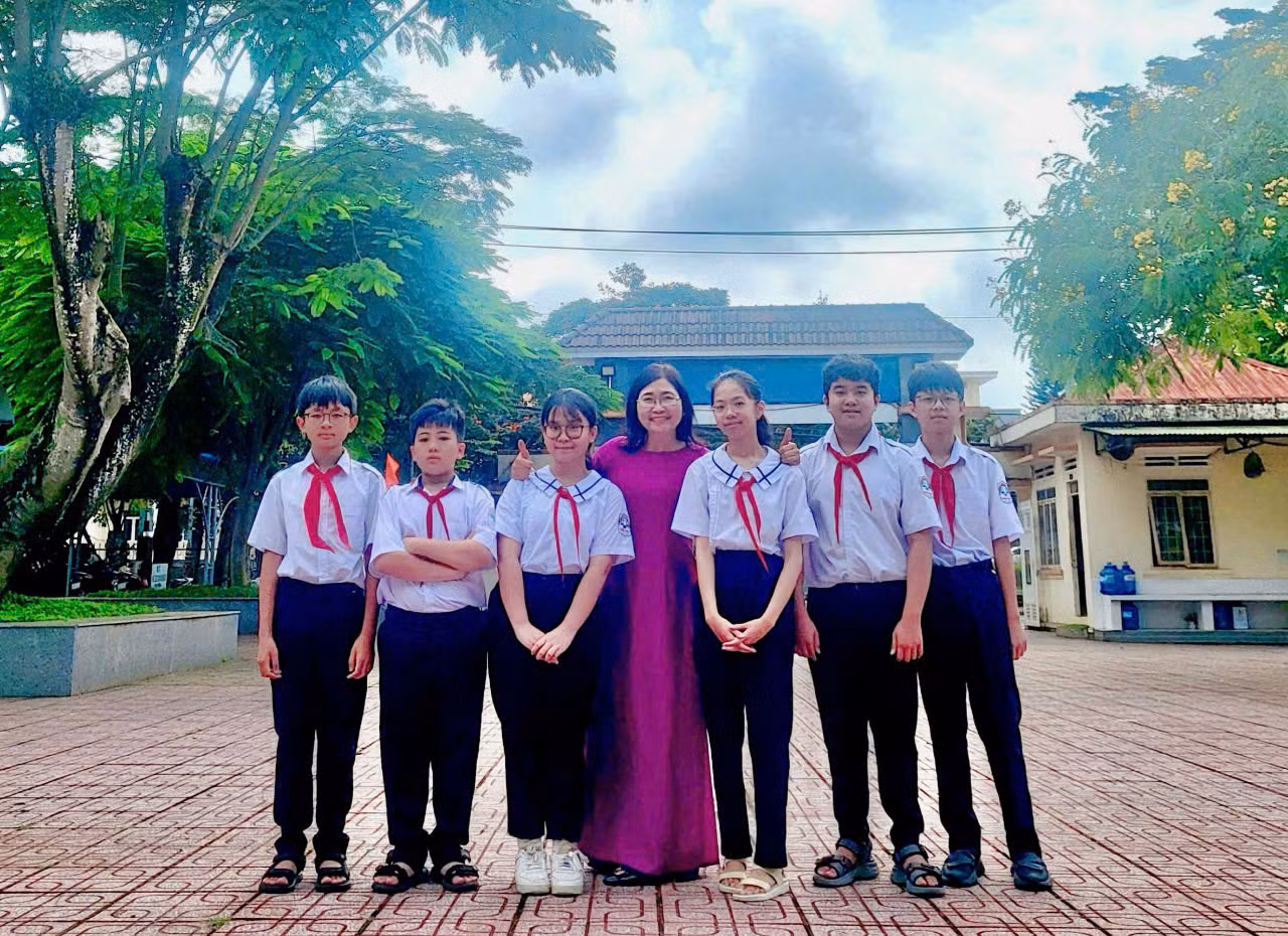 Nhật Minh (thứ hai từ phải sang) chụp ảnh cùng giáo viên chủ nhiệm và bạn bè. Ảnh: NVCC