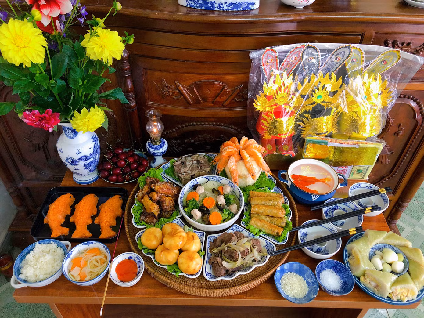 Mâm cỗ cúng ông Công ông Táo gồm có: Canh bóng thập cẩm, giò xào, nem rán, bò sốt tiêu đen kèm bánh bao, bánh chưng, gà rang muối, tôm hấp nước dừa, xôi gấc hình cá chép. Ảnh: NVCC