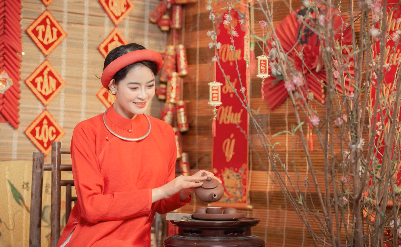 Thiếu nữ tạo dáng bên hoa đào, đèn lồng, bao lì xì, câu đối đỏ trong không khí giản dị, ấm cúng. Ảnh: Nguyễn Văn Tuấn.