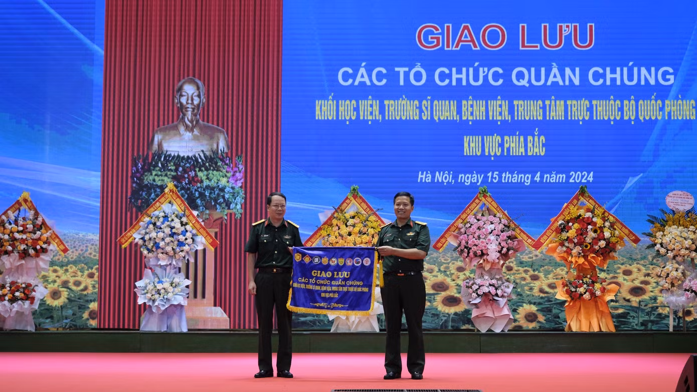 Đại tá Nguyễn Quang Đông - Phó Chủ nhiệm Chính trị Trường Sĩ quan Lục quân 1 trao cờ cho đơn vị đăng cai tổ chức tiếp theo. Ảnh: Châu Linh