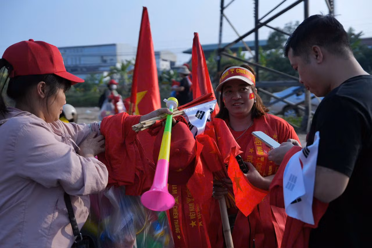 Khi giờ thi đấu diễn ra rất gần, khu vực bán đồ cổ vũ vô cùng sôi động, tấp nập khách ra vào.