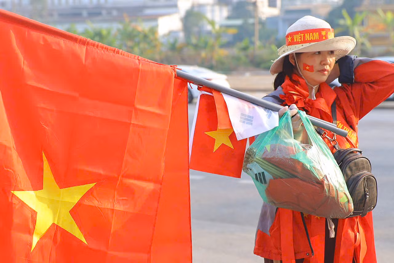 Khi các cổ động viên chưa đổ về, xung quanh sân vận động Việt Trì đã rực đỏ màu cờ, được tạo ra bởi những người bán đồ cổ vũ.