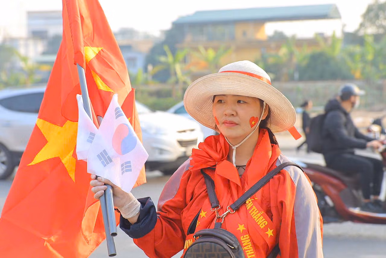 Cờ Tổ quốc là thứ không thể thiếu của người hâm mộ Việt Nam trong các trận đấu. Giống như thời HLV Park Hang-seo, khi HLV Kim Sang-sik dẫn dắt ĐT Việt Nam, bên cạnh lá cờ đỏ còn có cả cờ Hàn Quốc. Những lá cờ nhỏ được bán với giá 20.000 đồng, trong khi lá cờ to có giá 100.000 đồng.