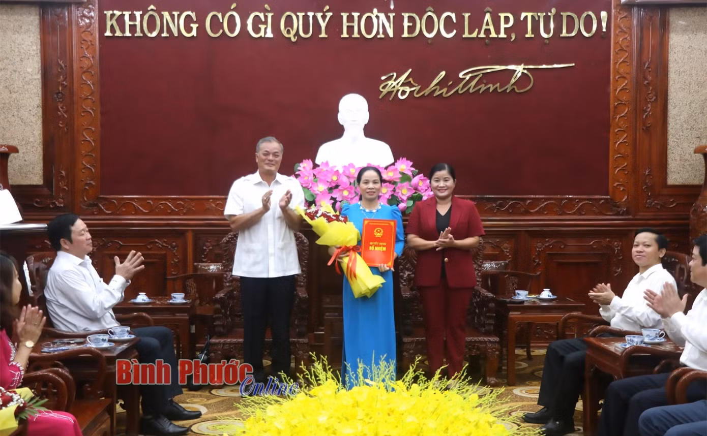 Chủ tịch UBND tỉnh Trần Tuệ Hiền và Ủy viên Ban Thường vụ, Trưởng ban Tổ chức Tỉnh ủy Nguyễn Hồng Trà trao quyết định bổ nhiệm, tặng hoa cho Giám đốc Sở Y tế Đỗ Thị Nguyên