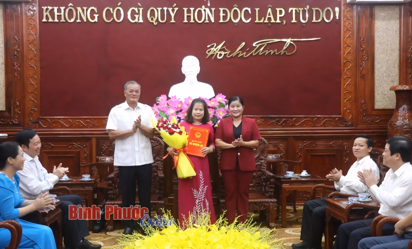 Chủ tịch UBND tỉnh Trần Tuệ Hiền và Ủy viên Ban Thường vụ, Trưởng ban Tổ chức Tỉnh ủy Nguyễn Hồng Trà trao quyết định bổ nhiệm lại, tặng hoa cho Chủ tịch Công ty TNHH MTV Xổ số kiến thiết và Dịch vụ tổng hợp Bình Phước Nguyễn Thị Thanh Thủy
