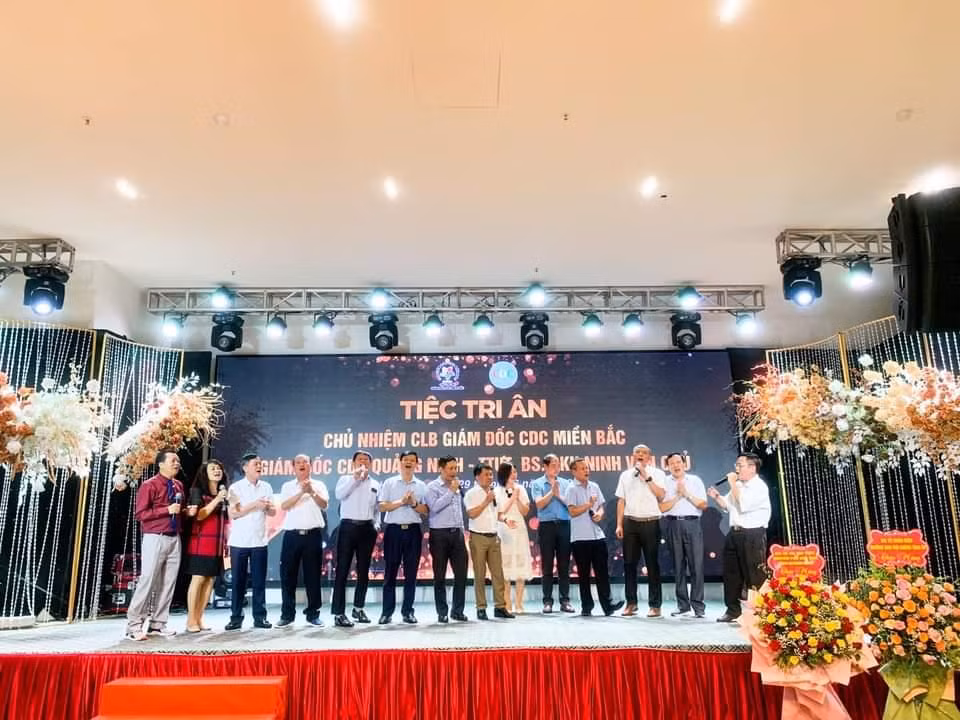 Ông Ninh Văn Chủ (người mặc áo đỏ ngoài cùng từ bên trái vào) cùng các vị khách hát mừng trong bữa tiệc tri ân trước khi về hưu.