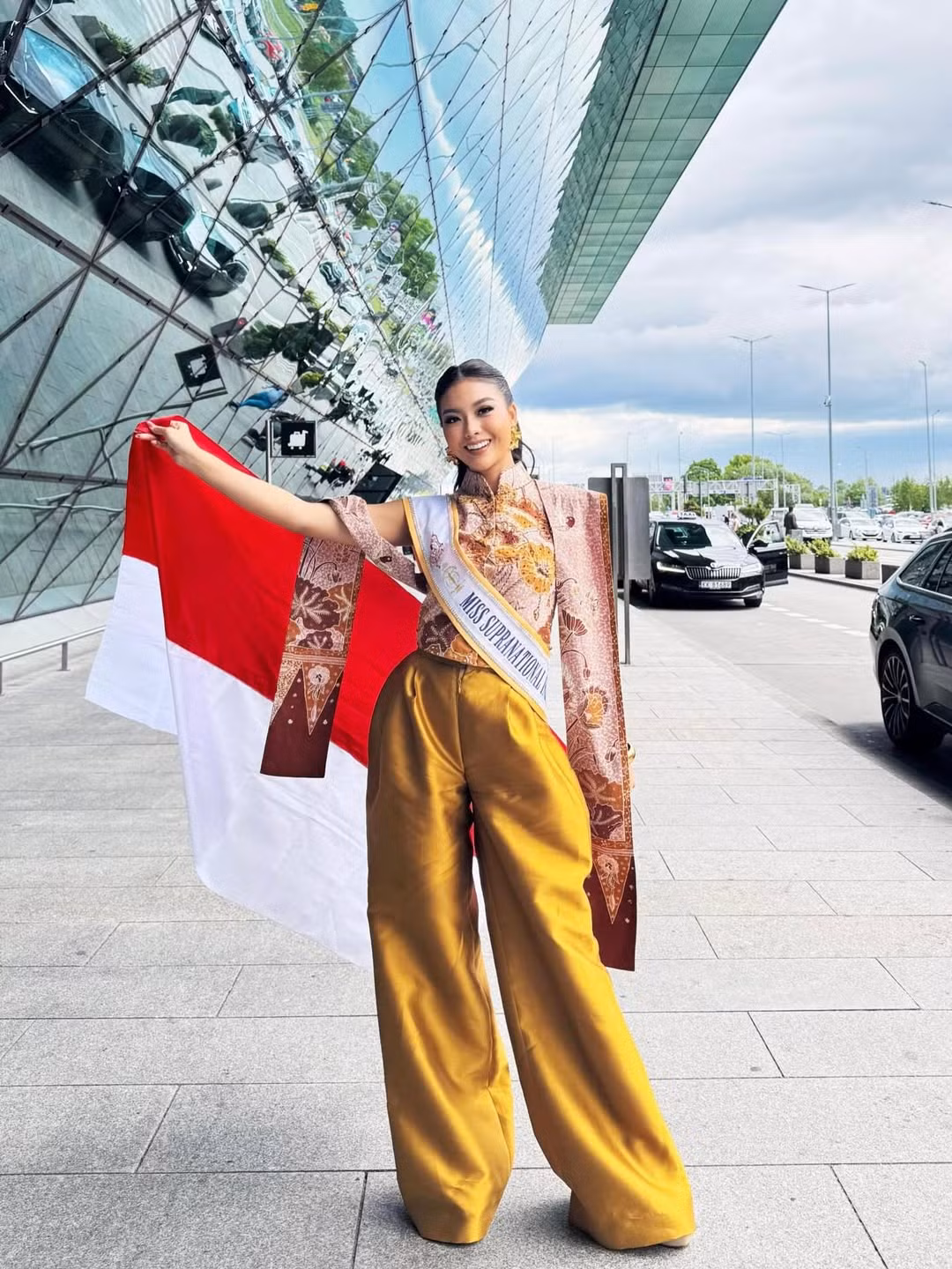 Đại diện Indonesia - Firsta Yufi Amarta Putri - nổi bật ở sân bay với trang phục mang họa tiết truyền thống. Firsta Yufi Amarta Putri năm nay 24 tuổi là cử nhân chuyên ngành tâm lý học. Cô được đánh giá cao ở trình độ học vấn và giao tiếp, ứng xử. Người đẹp đăng quang danh hiệu Puteri Indonesia 2025 và được cử làm đại diện Indonesia ở Hoa hậu Siêu quốc gia.