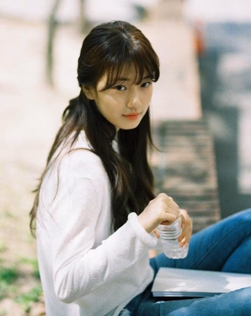 Suzy gắn với biệt danh "tình đầu" sau khi đóng vai chính trong Architecture 101 (2012). Hình ảnh cô sinh viên đại học với mái tóc dài, gương mặt thanh tú, khí chất dịu dàng luôn khiến nhiều người hâm mộ nam phải say đắm. Ảnh: Architecture 101.