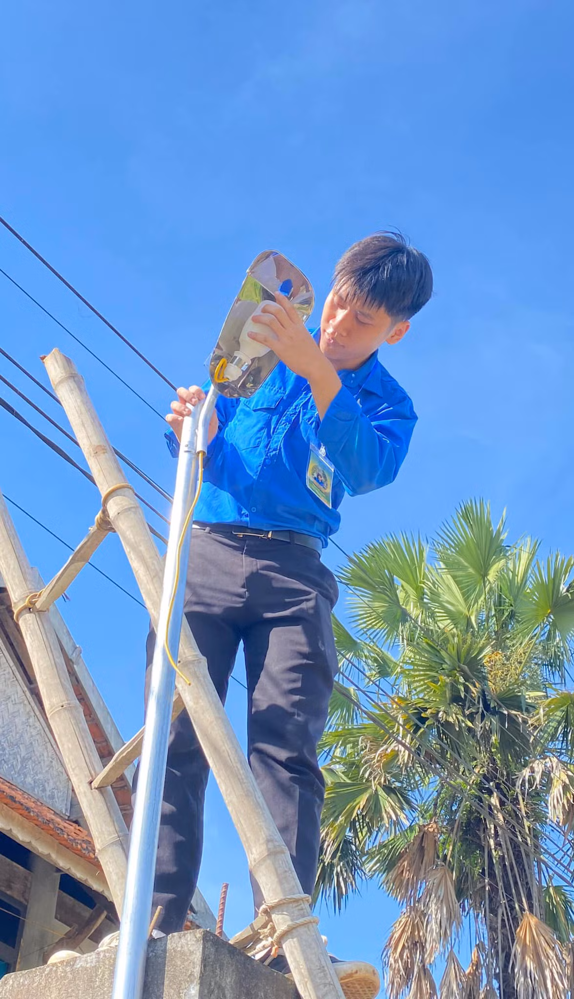 Đoàn viên thanh niên thực hiện lắp bóng đèn tại địa phương. Ảnh: Đoàn Thanh niên - Hội Sinh viên HUMG