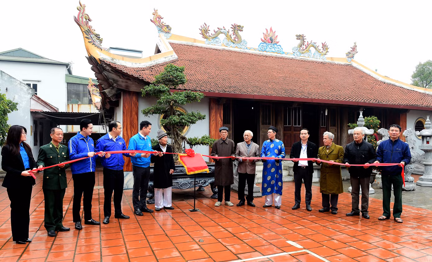 Các bậc cao niên cùng đại diện Đoàn Thanh niên thực hiện nghi thức khánh thành công trình bảng quét mã thông tin di tích đình Thượng Đồng. Ảnh: Xuân Tùng