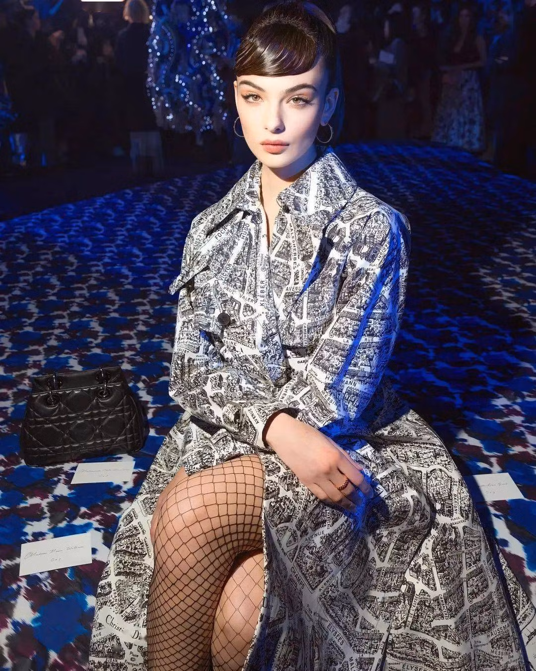 Deva tại buổi trình diễn Dior tại Tuần lễ thời trang Paris năm 2023. Cô ấy chỉ mặc độc một chiếc áo gió in hình họa tiết báo, với phần tóc mái bằng cổ điển và lông mày hiện đại cũng đủ để 'hút hồn' người đối diện, giống như một cô gái bước ra từ trong tranh.