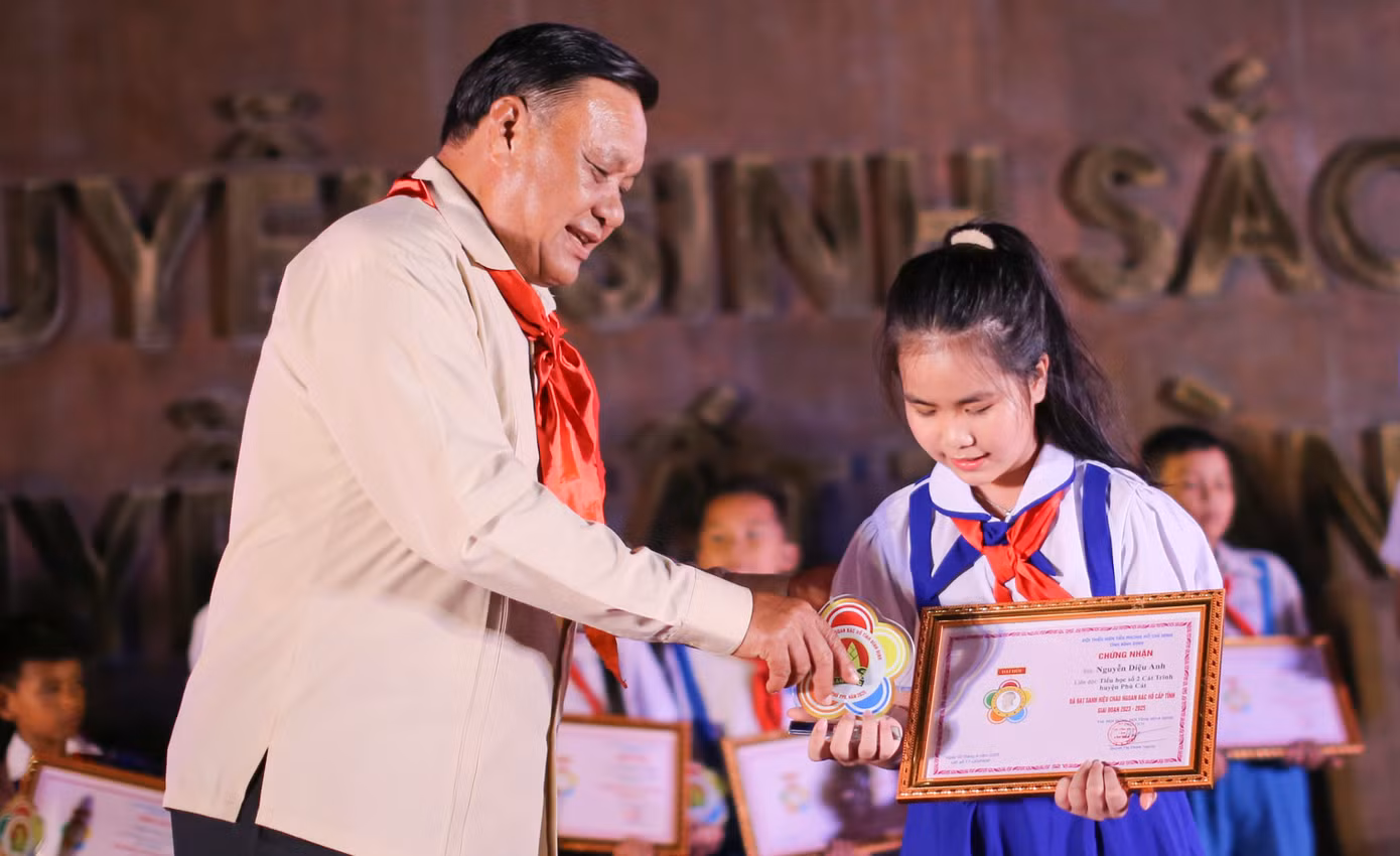 Ông Lê Kim Toàn - Phó Bí thư Thường trực Tỉnh ủy, Trưởng đoàn Đoàn ĐBQH tỉnh Bình Định trao danh hiệu cháu ngoan Bác Hồ cho các em thiếu nhi. Ảnh: Trương Định