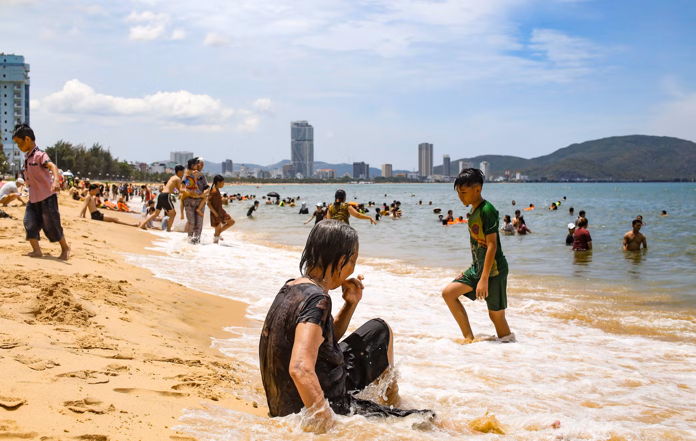 Nhiều người sau khi tắm xong không quên mang nước biển về cho người thân ở nhà. Ảnh: Trương Định.