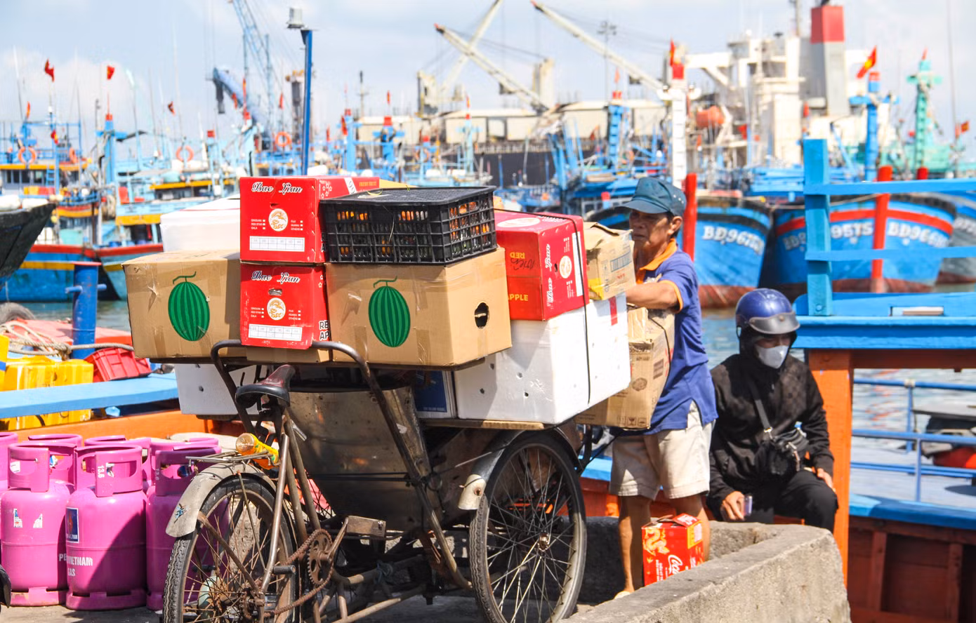 Từng chiếc xe ba gác, xích lô chở hàng đến để đưa xuống đò. Trên boong đò, chất đầy ắp những nhu yếu phẩm cho ngày Tết. Ảnh: Trương Định