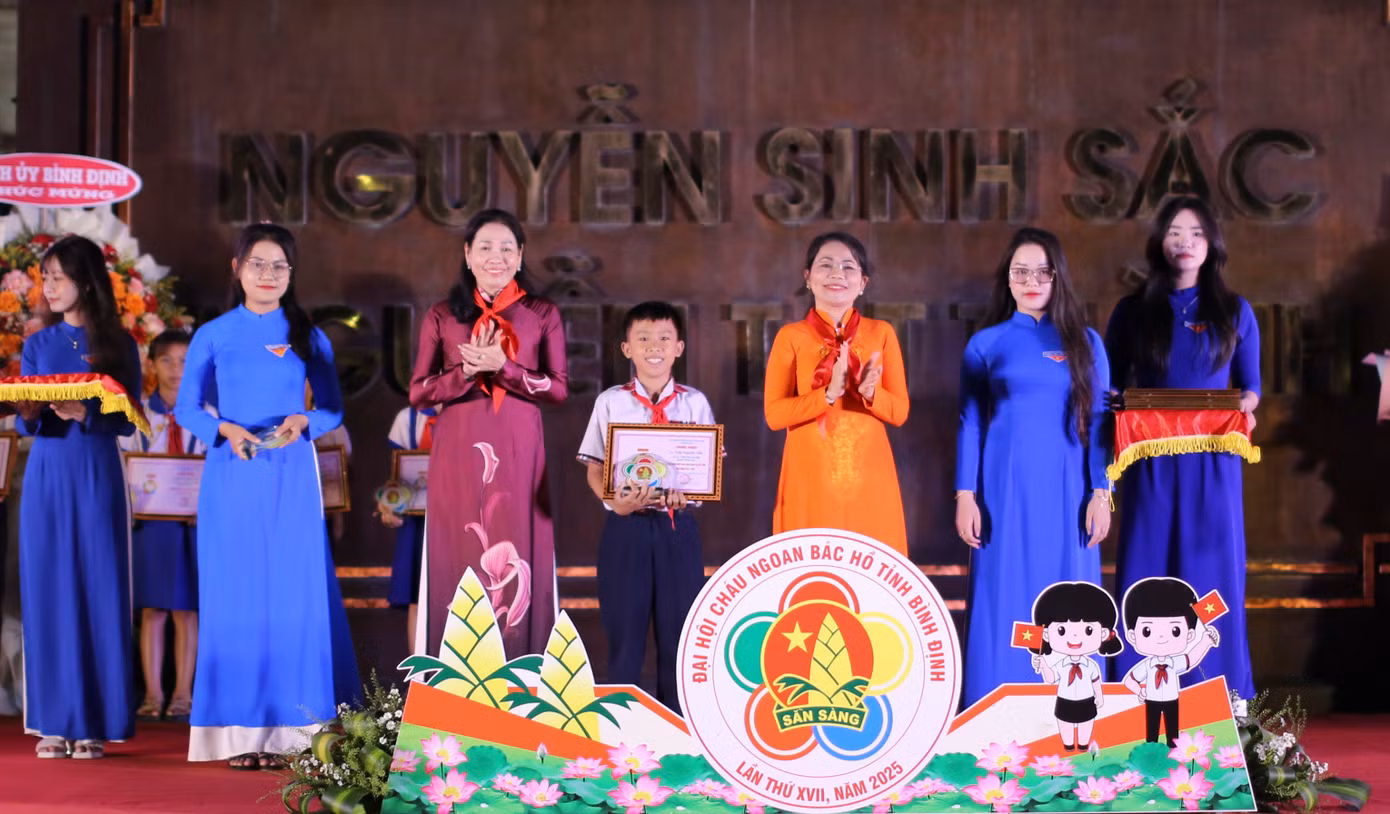 Bà Nguyễn Thị Phong Vũ - Trưởng Ban Tuyên giáo và Dân vận Tỉnh ủy Bình Định (bên phải) cùng bà Huỳnh Thúy Vân - Phó Chủ tịch HĐND tỉnh Bình Định trao tặng danh hiệu cho các em thiếu nhi. Ảnh: Trương Định
