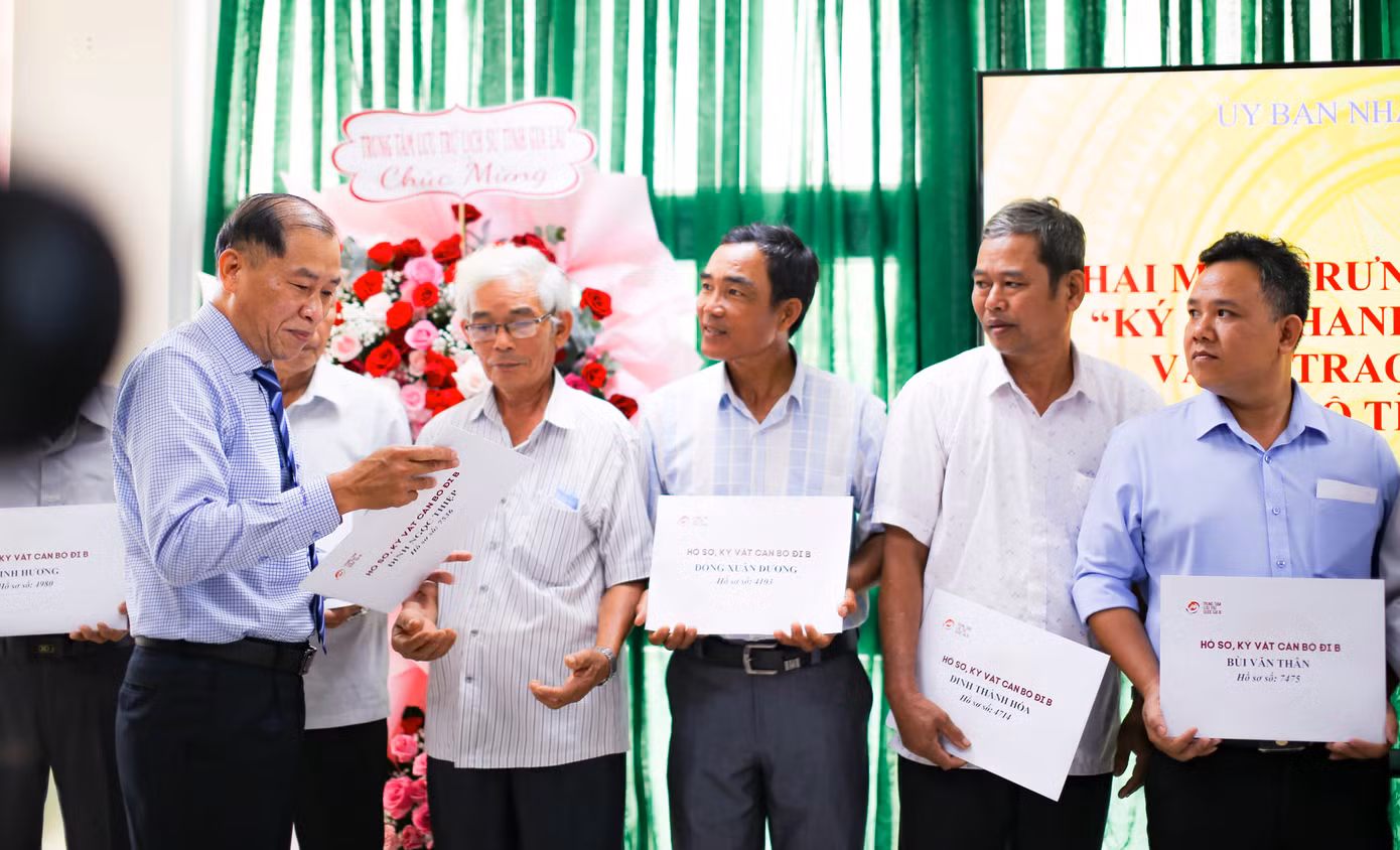Ông Lê Minh Tuấn - Giám đốc Sở Nội vụ tỉnh Bình Định (bên trái) - trao lại hồ sơ, kỷ vật cán bộ tỉnh Bình Định đi B cho người thân các gia đình. Ảnh: Trương Định.