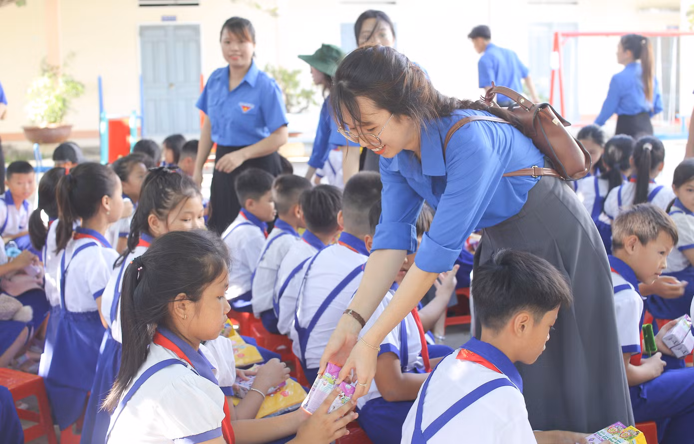Tặng sữa cho các em học sinh. Ảnh: Trương Định