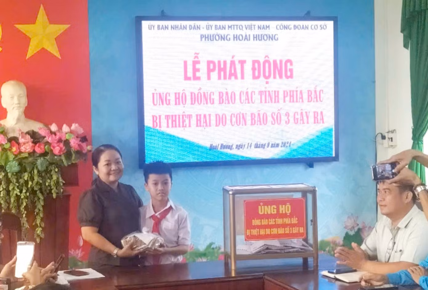 Sáng nay (14/9), em Trịnh Hồng Vinh cùng mẹ mang số tiền gom góp được tới trụ sở phường Hoài Hương để ủng hộ. Ảnh: Gia đình cung cấp Sáng nay (14/9), em Trịnh Hồng Vinh cùng mẹ mang số tiền gom góp được tới trụ sở phường Hoài Hương để ủng hộ. Ảnh: Gia đình cung cấp