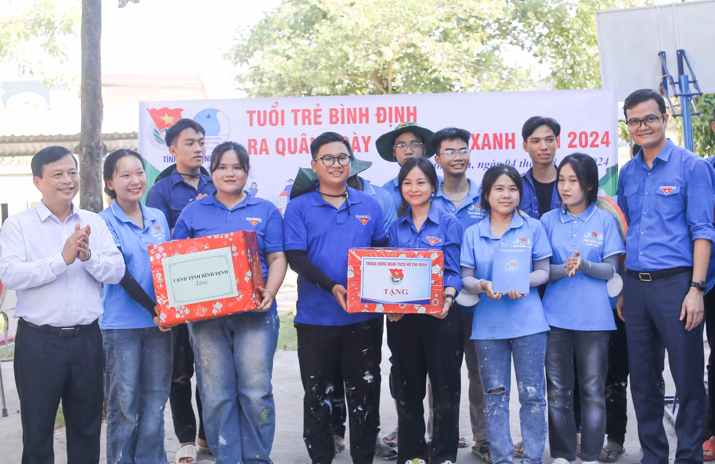 Anh Bùi Quang Huy (bên phải) cùng ông Nguyễn Tuấn Thanh (bên trái) tặng quà cho đội TNTN. Ảnh: Trương Định