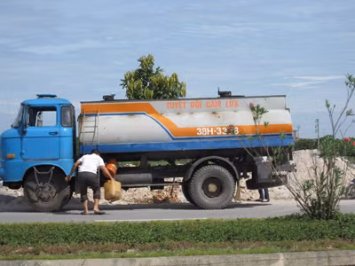 Một lái xe đang rút xăng để bán
