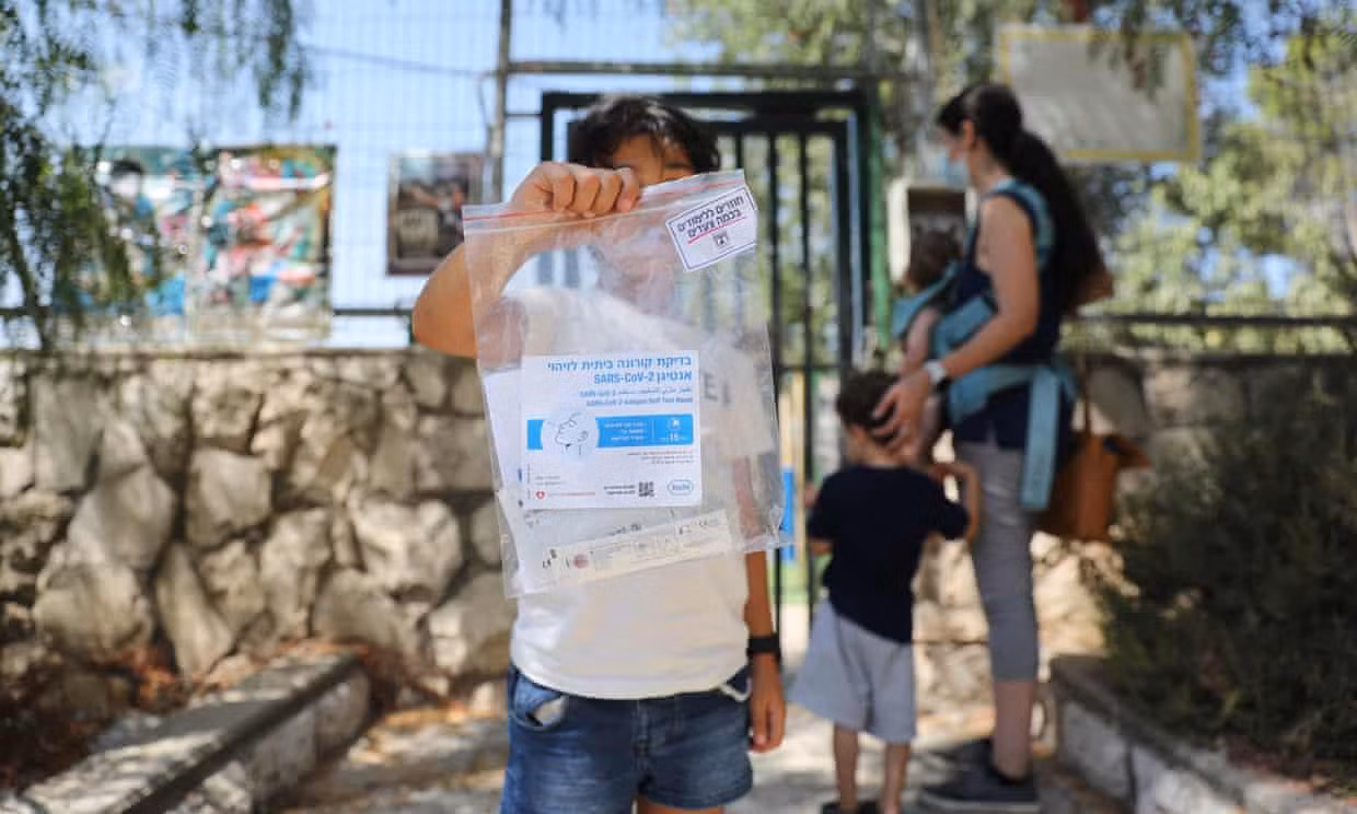 Một bé gái Israel cầm kit test trong chiến dịch xét nghiệm hàng loạt trước khi mở cửa trường học trở lại. Ảnh: EPA
