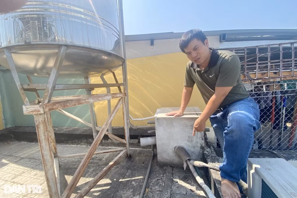 Ông Huy đứng trên bồn nước của gia đình và khẳng định không có sự cố tràn ra ngoài trong thời gian trên (Ảnh: An Huy).