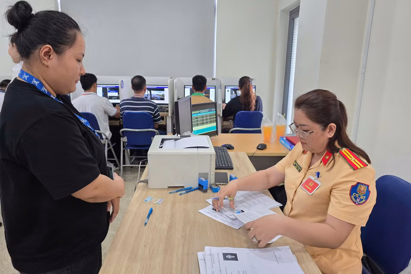 CSGT hướng dẫn người dân thực hiện thủ tục thi. Ảnh: H.T.