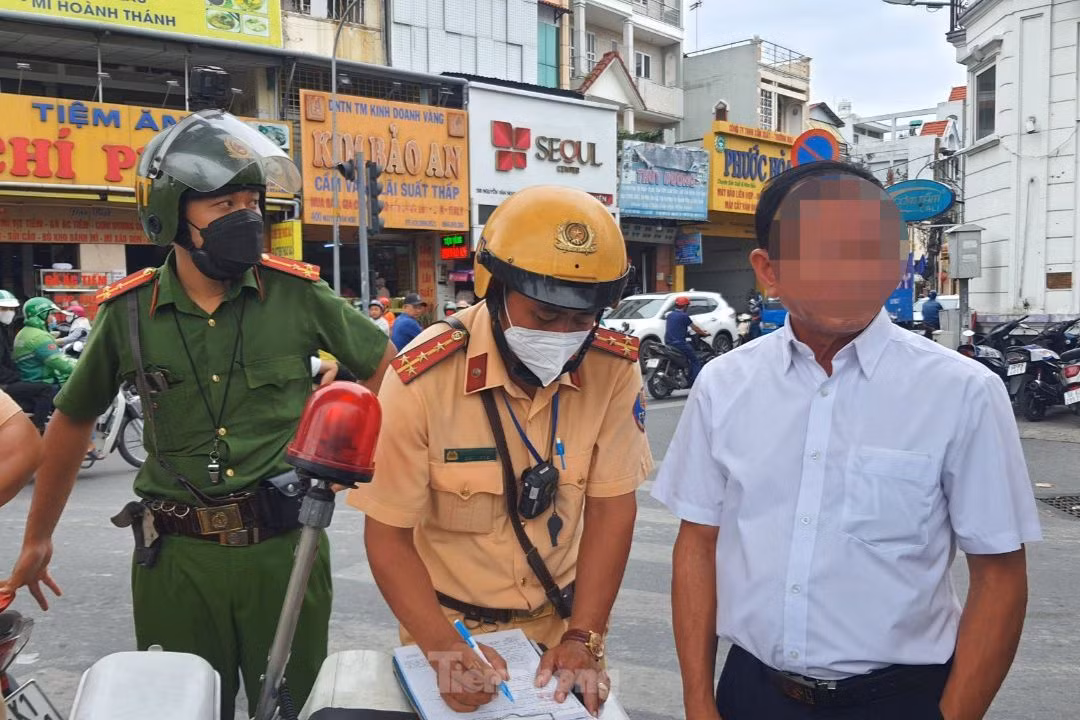 Lực lượng CSGT lập biên bản xử phạt hành chính đối với ông N.Q.T.. Ảnh: Hoàng Thuận