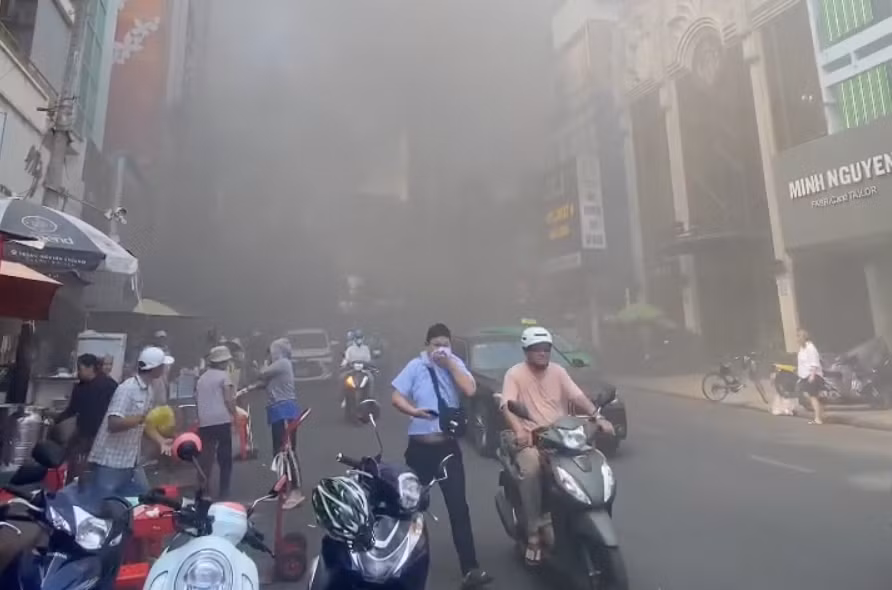 Người dân bịt mũi vì khói bốc lên từ đám cháy. Ảnh: A.X
