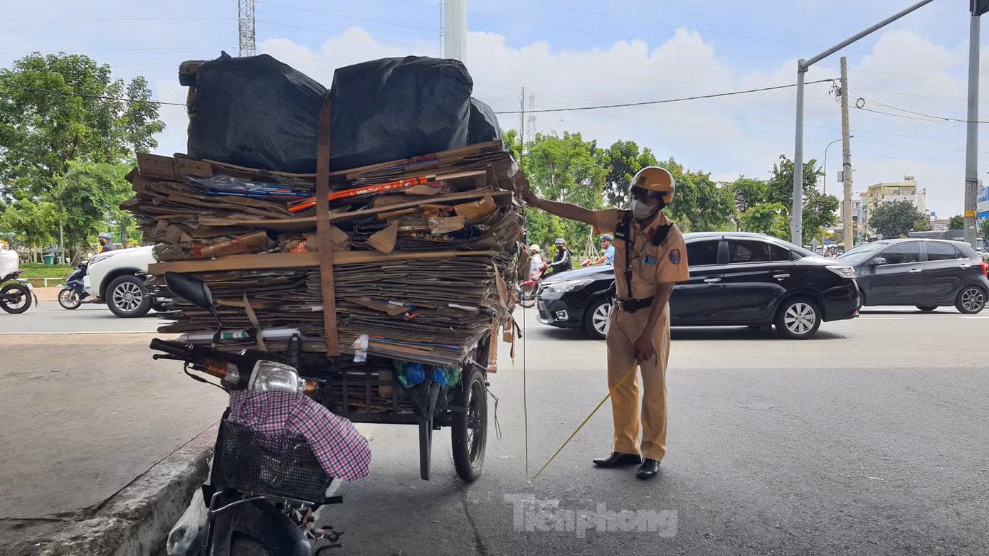Xe máy gắn xe lôi tự chế chất thùng carton cao hơn 2m. Ảnh: Hoàng Thuận.