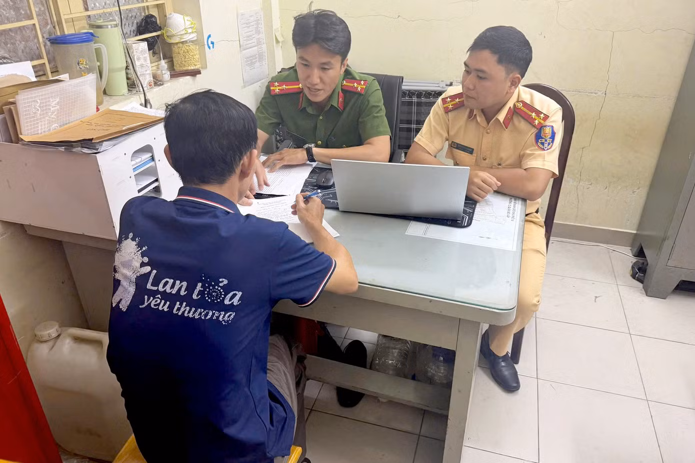 Công an làm việc với người đàn ông trong nhóm chiếm đường để chơi bóng bàn. Ảnh: Công an cung cấp.