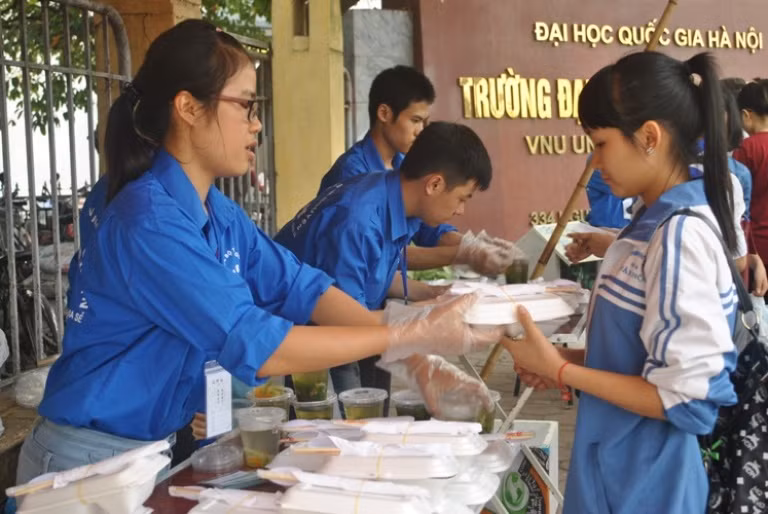 Các tình nguyện viên phát cơm chay cho sinh viên 