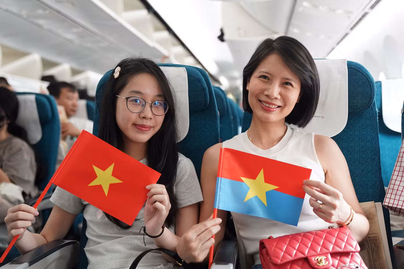 Có mặt trên chuyến bay đặc biệt VN209 hôm nay (30/4) của Vietnam Airline, chị Lê Phương Quỳnh (áo trắng) cho biết, nhân dịp kỷ niệm 50 giải phóng miền Nam, thống nhất đất nước, chị và gia đình quyết định bay từ Hà Nội vào TPHCM để du lịch. Tuy nhiên, ngay từ khi bước lên máy bay, chị đã cảm nhận được không khí rộn ràng của đại lễ đặc biệt này. Ảnh: VNA.