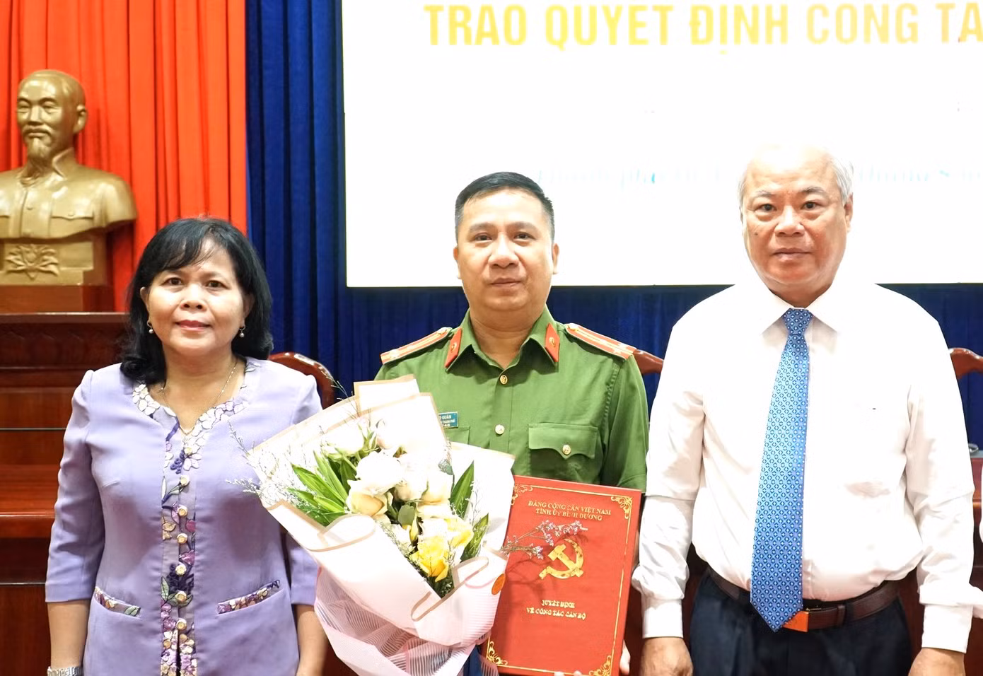 Thượng tá Đàm Bảo Quân (giữa) nhận quyết định chuẩn y Ủy viên Ban Thường vụ Thành ủy Dĩ An