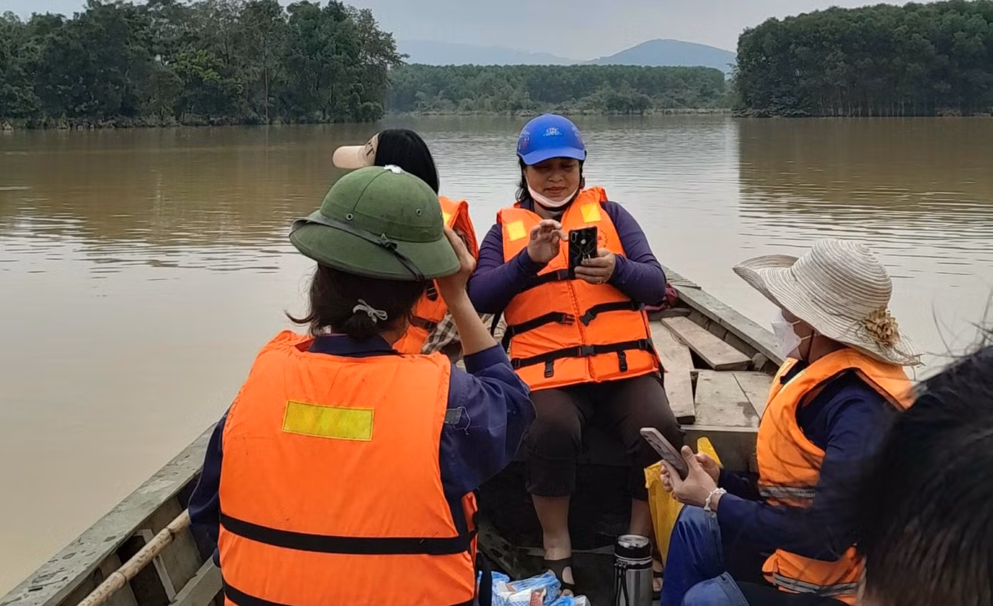 Giáo viên Trường mầm non Điền Mỹ chuyển bằng thuyền vào trường để dọn bùn sau khi lũ rút.