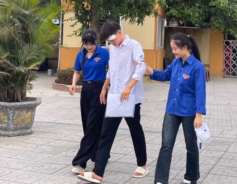 Các tình nguyện viên hỗ trợ thí sinh vào phòng thi.