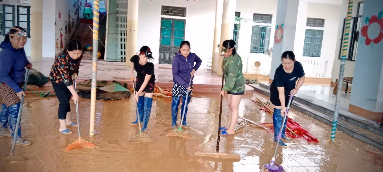 Cô Sự (áo hoa thứ 2 bìa trái) cùng giáo viên trong trường dọn bùn sau lũ.