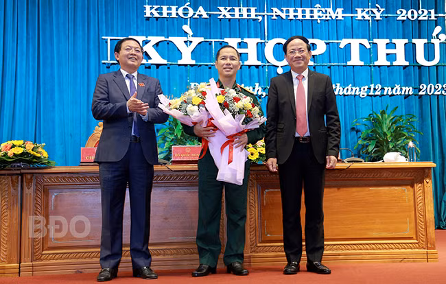 Bí thư Tỉnh ủy, Chủ tịch HĐND tỉnh Bình Định Hồ Quốc Dũng (bìa trái) và Chủ tịch UBND tỉnh Phạm Anh Tuấn (bìa phải) tặng hoa chúc mừng đại tá Đỗ Xuân Hùng. Ảnh: Báo Bình Định
