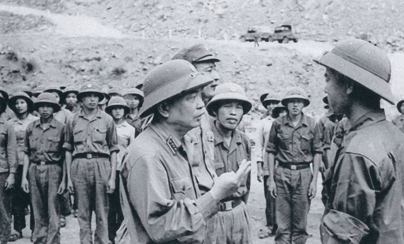 Đại tướng Võ Nguyên Giáp cùng Tướng Đồng Sỹ Nguyên đang nghe bộ đội báo cáo thi công đường chiến lược. Đại tướng Võ Nguyên Giáp cùng Tướng Đồng Sỹ Nguyên đang nghe bộ đội báo cáo thi công đường chiến lược.