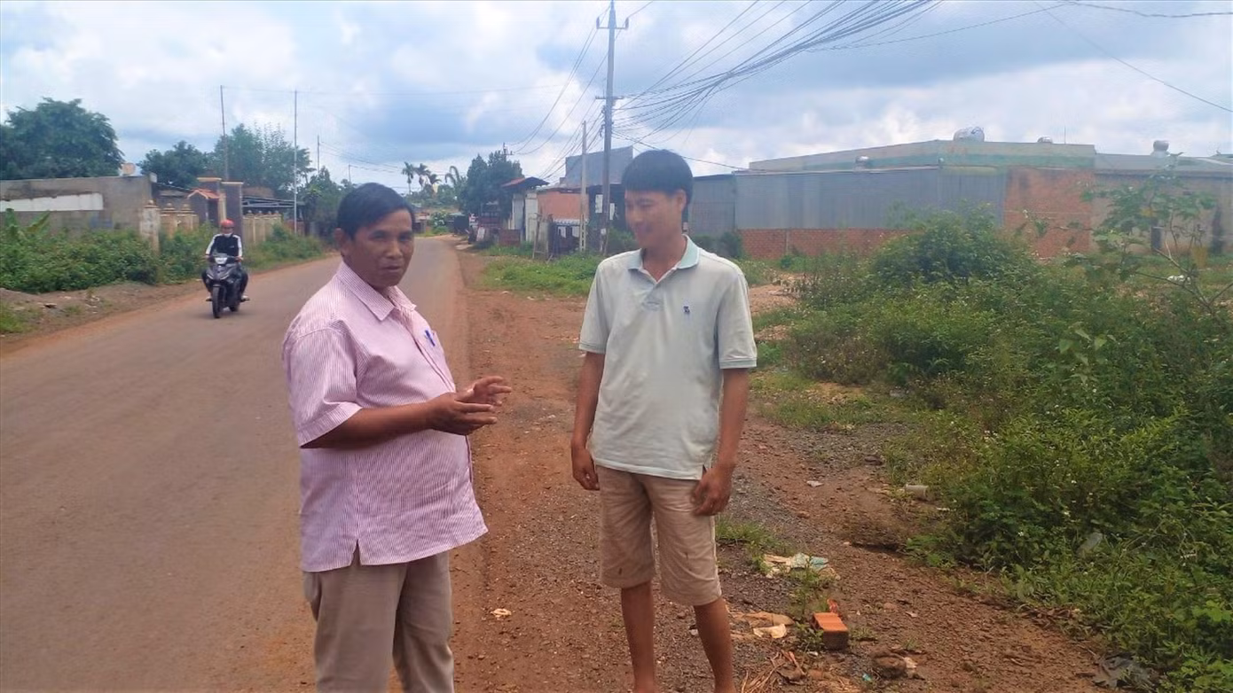 Anh Y Blun (bên trái), Chủ tịch Ủy ban Mặt trận Tổ quốc xã Ea Nam gặp gỡ người dân trước giờ làm thủ tục thi tốt nghiệp THPT 2022