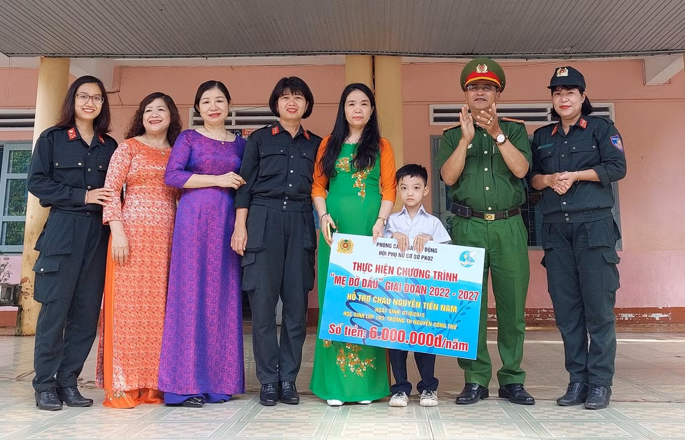 Đại diện lãnh đạo Phòng Cảnh sát cơ động trao bảng nhận đỡ đầu cho học sinh Nam và Ban giám hiệu nhà trường