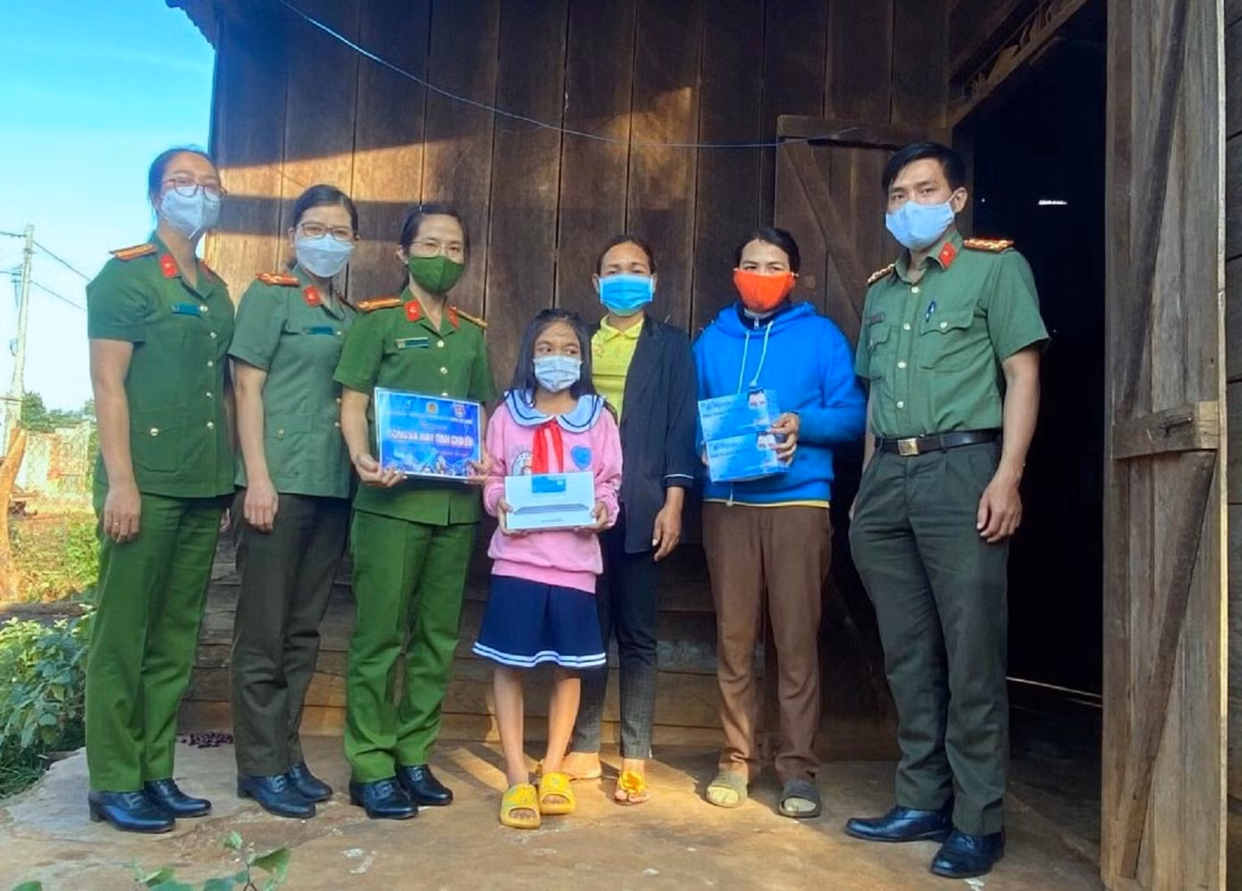 Đại úy Lãnh (phải) cùng cán bộ chiến sĩ công an trao tặng máy tính cho học sinh khó khăn