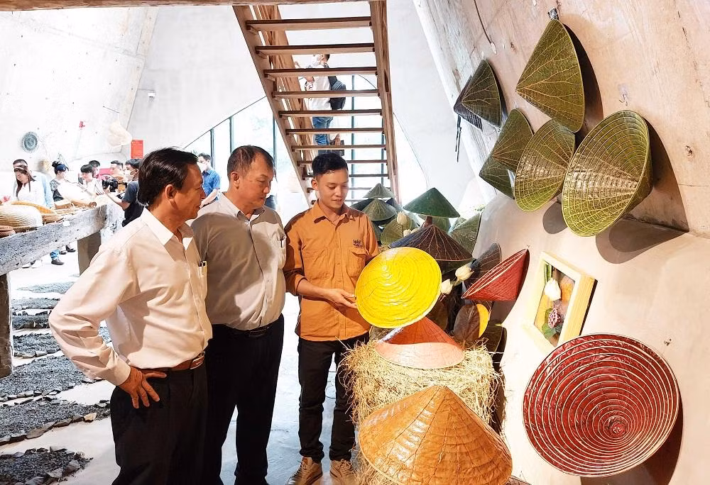 Họa sĩ Nguyễn Thanh Thảo (phải) giới thiệu nón lá sen