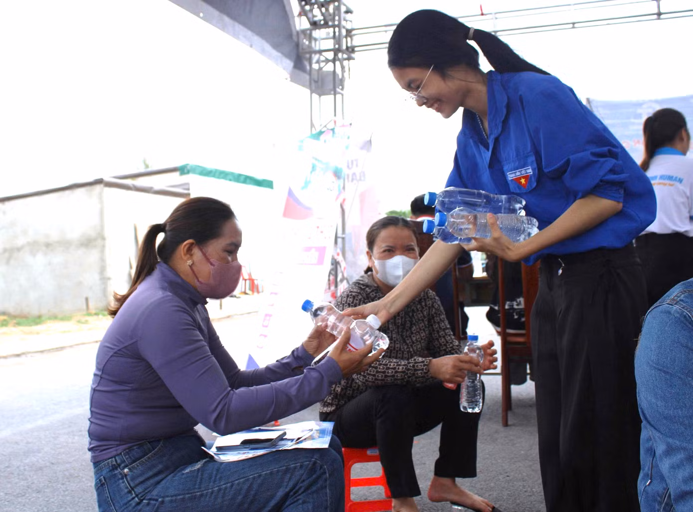 Tình nguyện viên phát nước cho các phụ huynh của thí sinh.