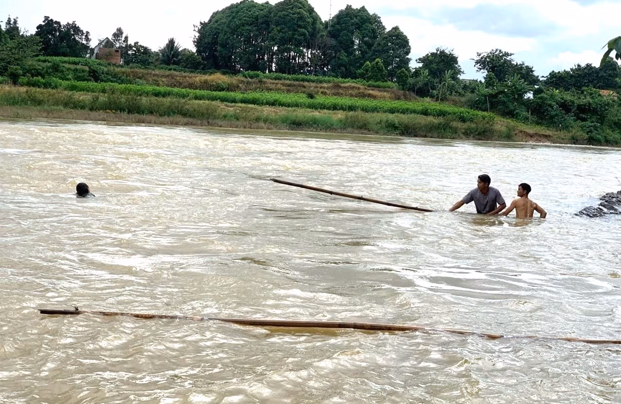 Các cán bộ và người dân xã Nam Ka cứu một bé gái bị đuối nước.